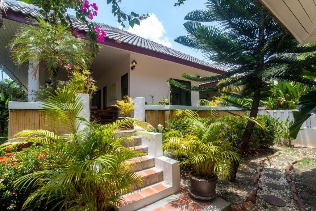 a house with palm trees and stairs in front of it at Southern Lanta A4 in Ko Lanta