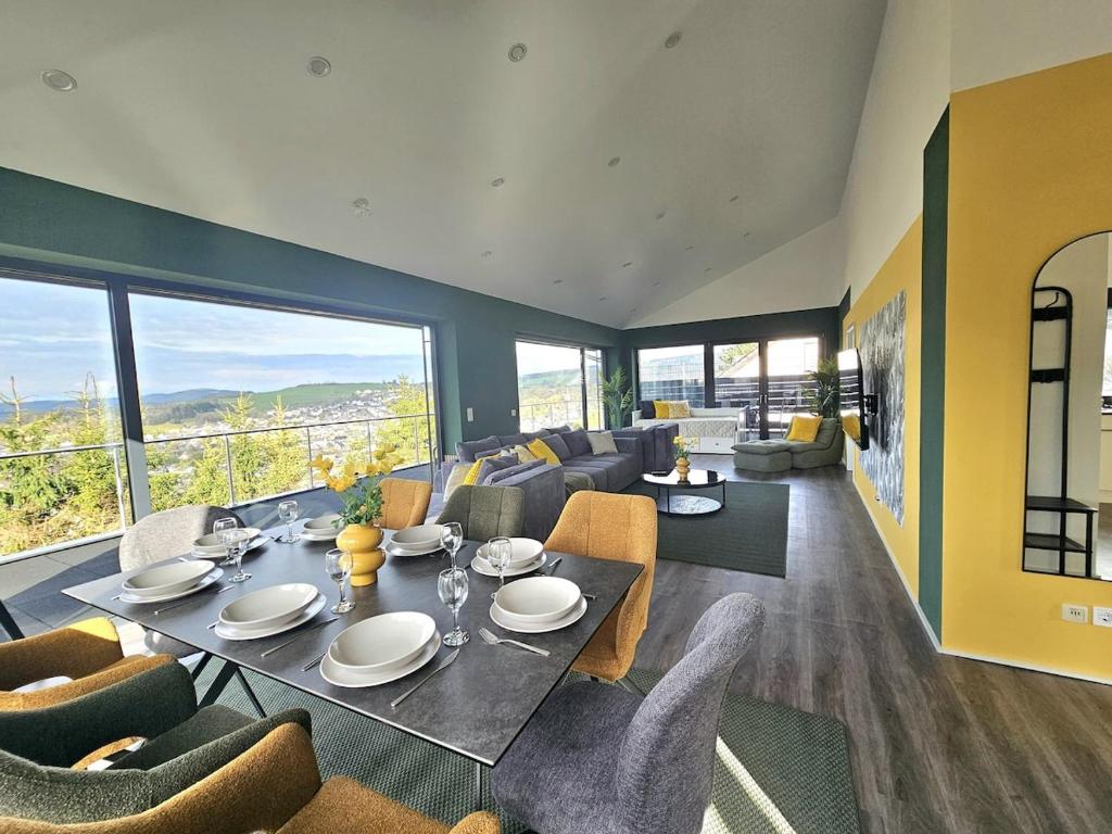a dining room and living room with a table and chairs at Luxus-Penthouse mit einzigartigem Schlossblick in Bad Berleburg