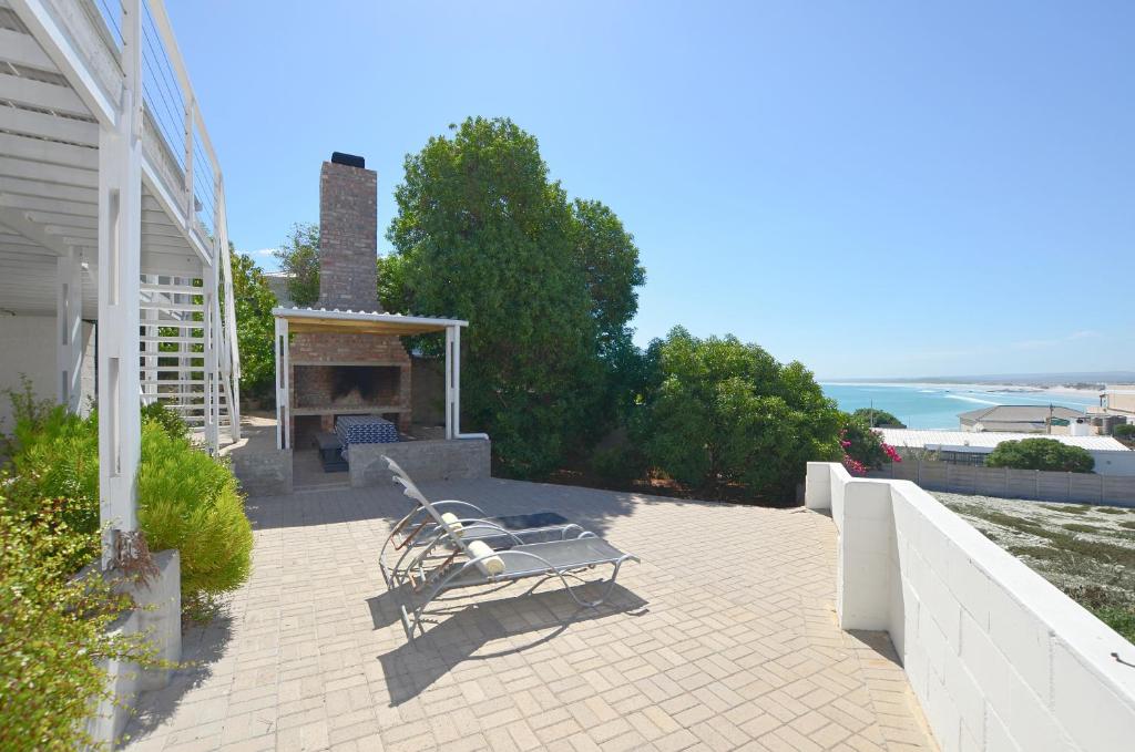 a patio with a bench and a fireplace on a house at Kommaweer in Yzerfontein