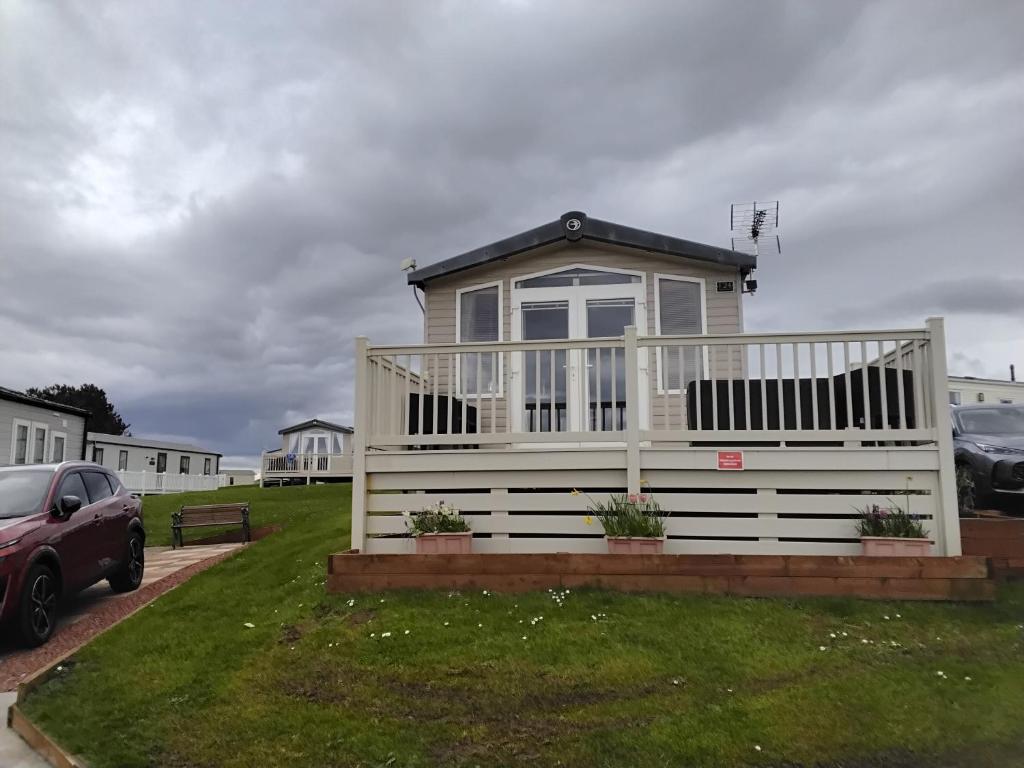 a small house with a white fence in a yard at The Bay View in Eyemouth