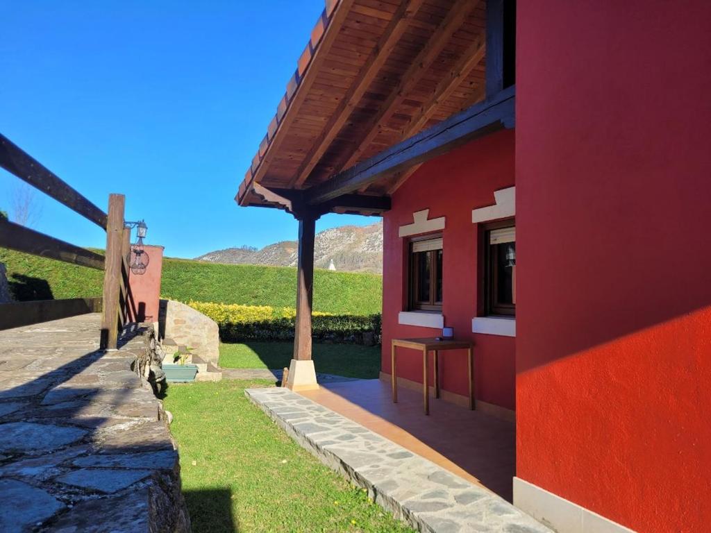 a red building with a view of a field at La Casuca in Celucos