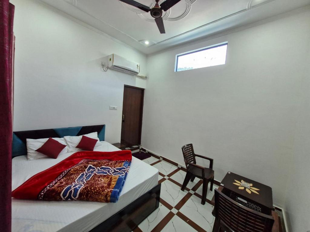 a bedroom with a bed and a chair and a window at Hotel Royal galaxy in Dharāsu