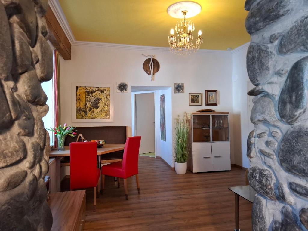 a dining room with a table and red chairs at Ferienwohnung Lienz Egger in Lienz