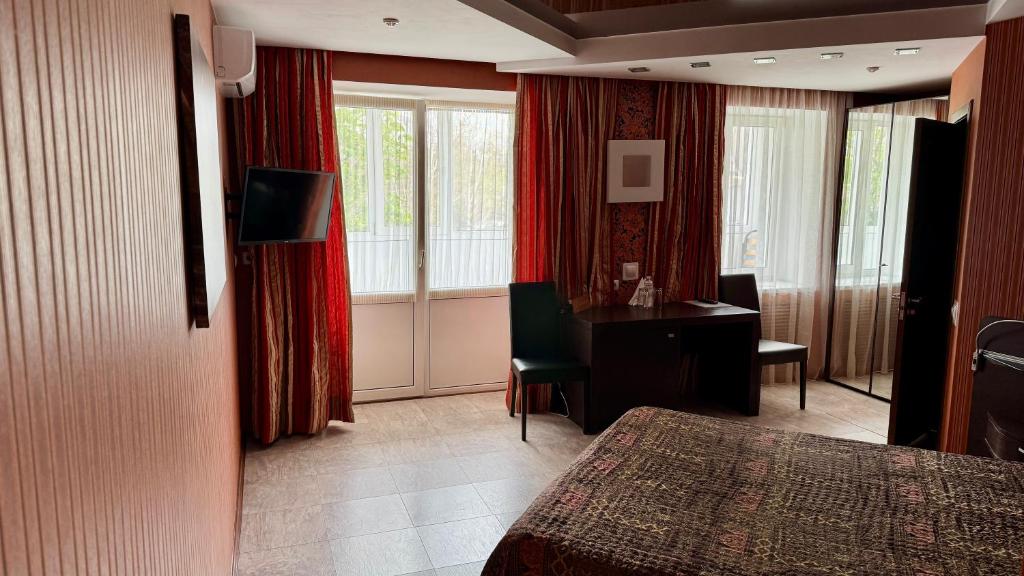 a hotel room with a desk and a bedroom at Okolytsia in Svitlovodsʼk