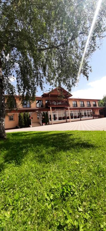 a large building in front of a field of green grass at Górska Dolina in Stronie Śląskie