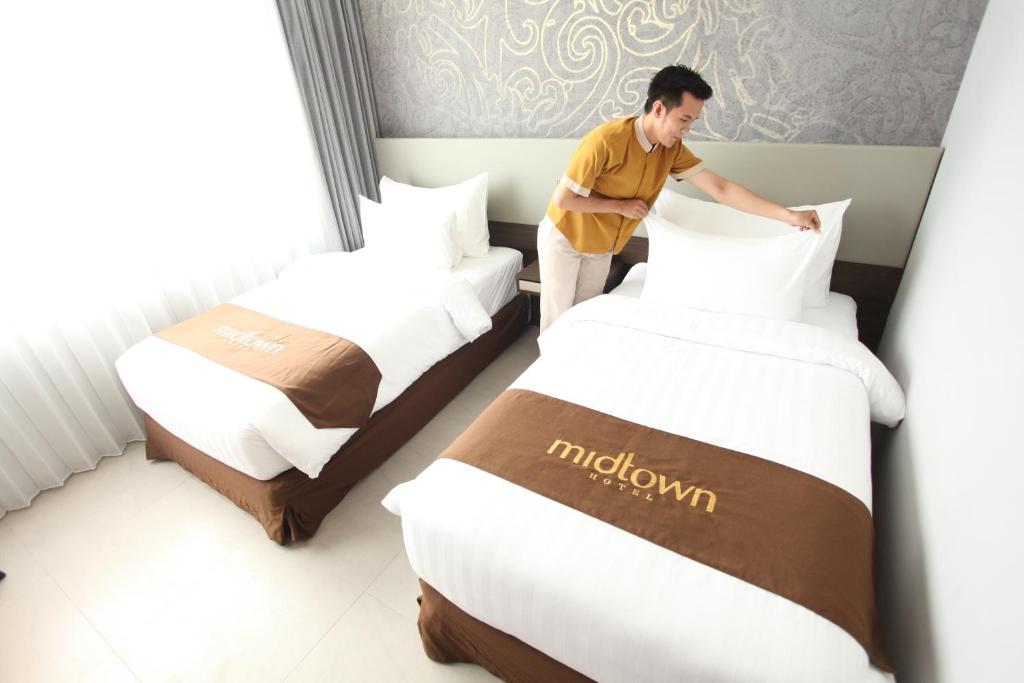 Postel nebo postele na pokoji v ubytování Midtown Hotel Samarinda