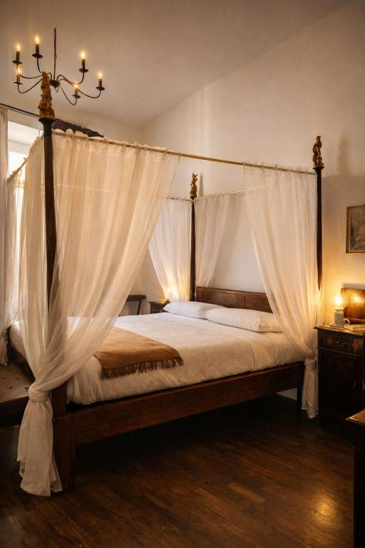 a bedroom with a canopy bed with white curtains at La Dama Stanca in Narni