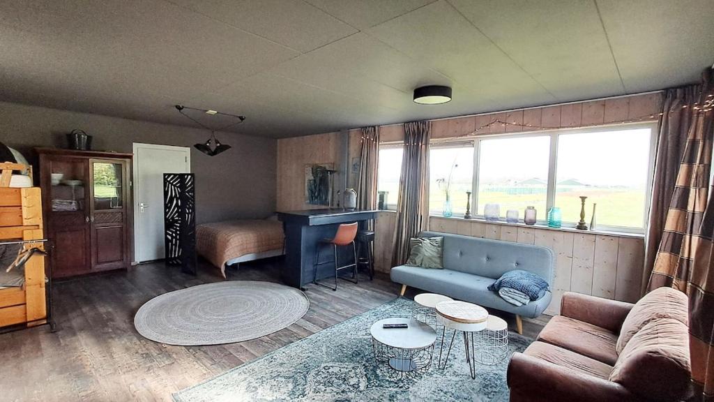 a living room with a couch and a table at Studio Rozenbottel shared bathroom in Hensbroek