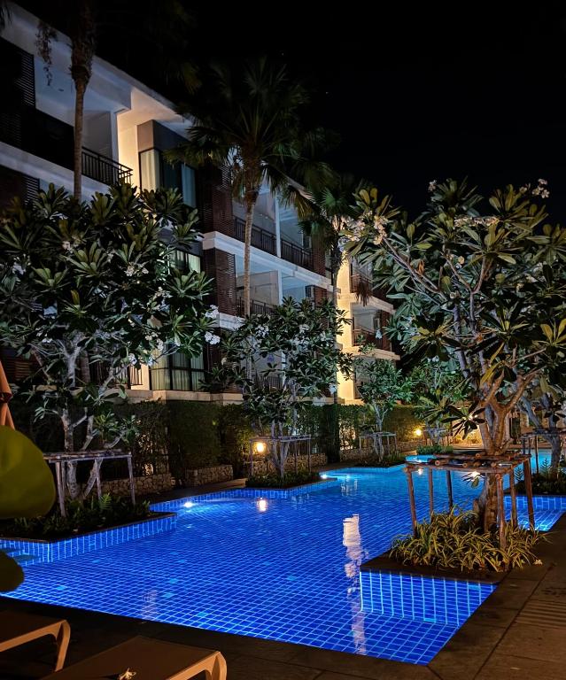 a swimming pool in front of a building at night at The Title Rawai in Ban Saiyuan (1)
