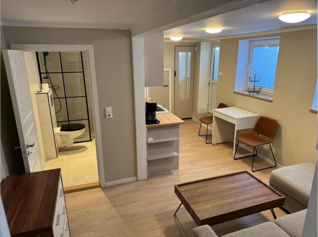 a living room with a table and a room with a bathroom at Hybel in Porsgrunn