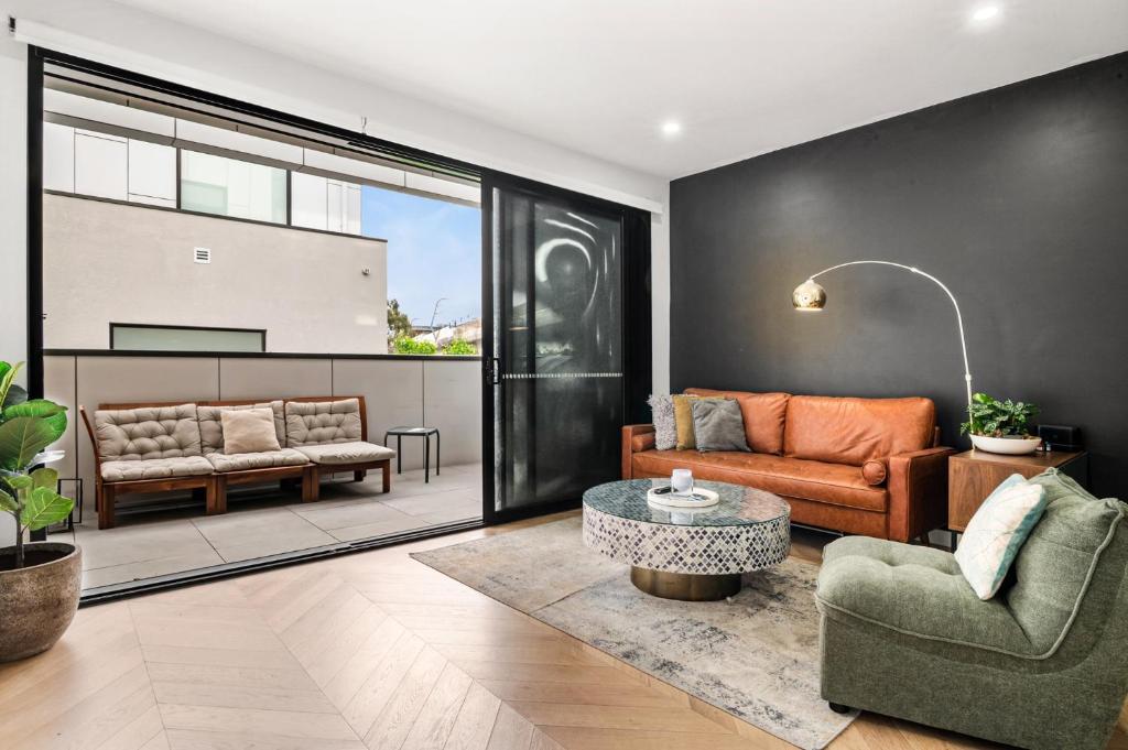 a living room with a couch and a table at Chic Home with BBQ & Outdoor Dining in Carnegie