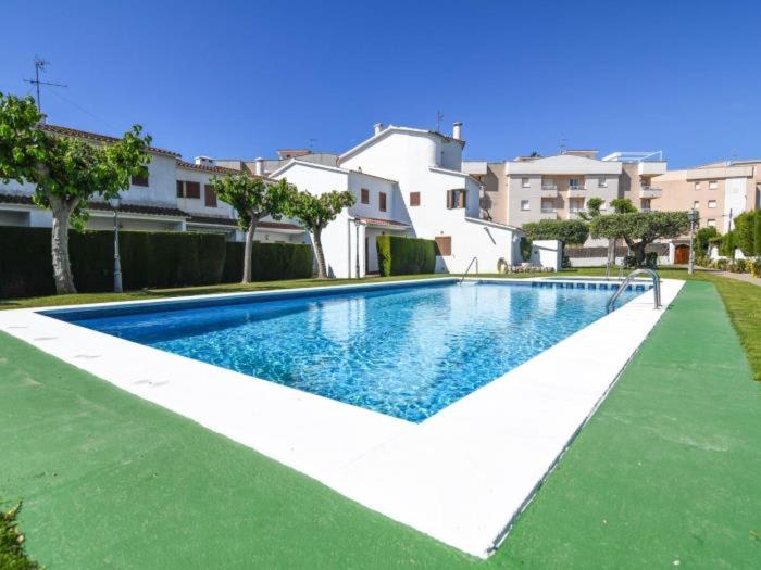 a large swimming pool in a yard with houses at Casa Socias in Comarruga