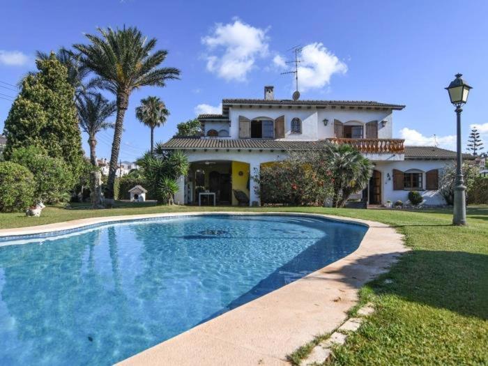 a house with a swimming pool in front of a house at Villa Maite in Roda de Bará