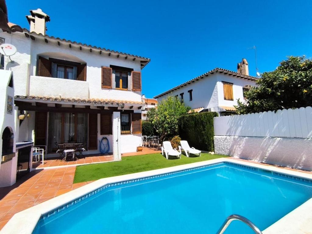 a villa with a swimming pool in front of a house at Casa Marti in Roda de Bará