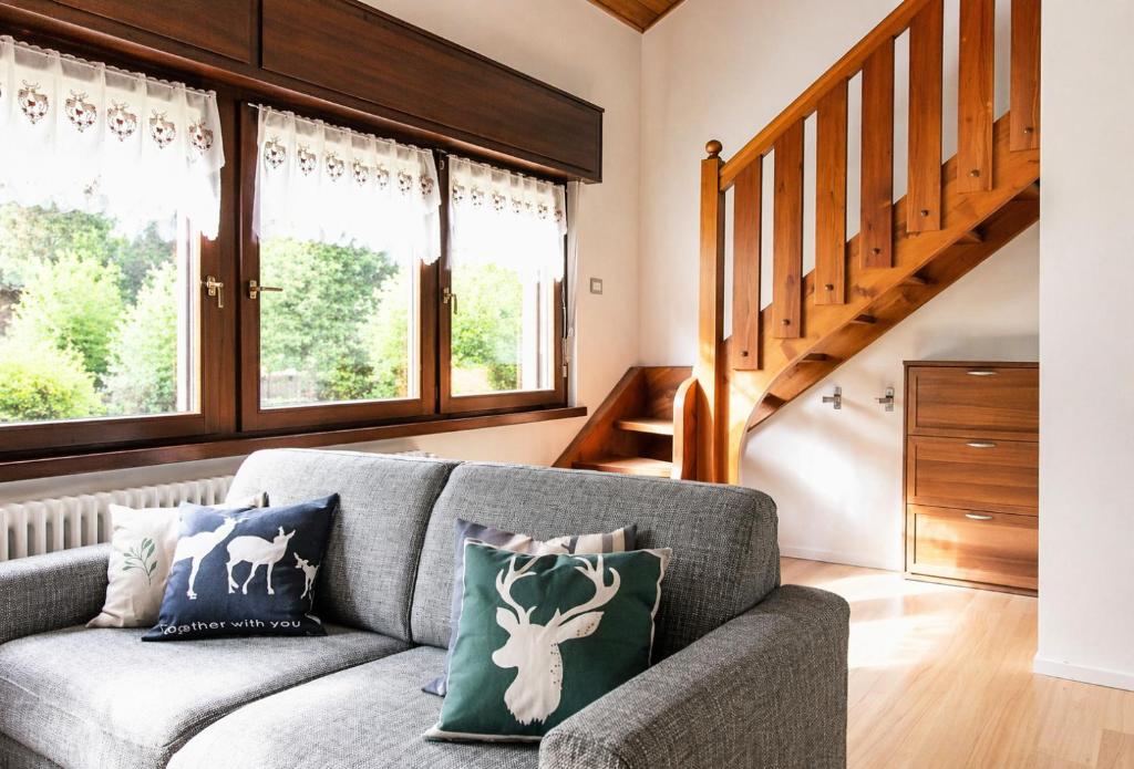 a living room with a couch and some windows at IL CERVO - 2 camere, garage Dolomiti Affitti in Cavalese