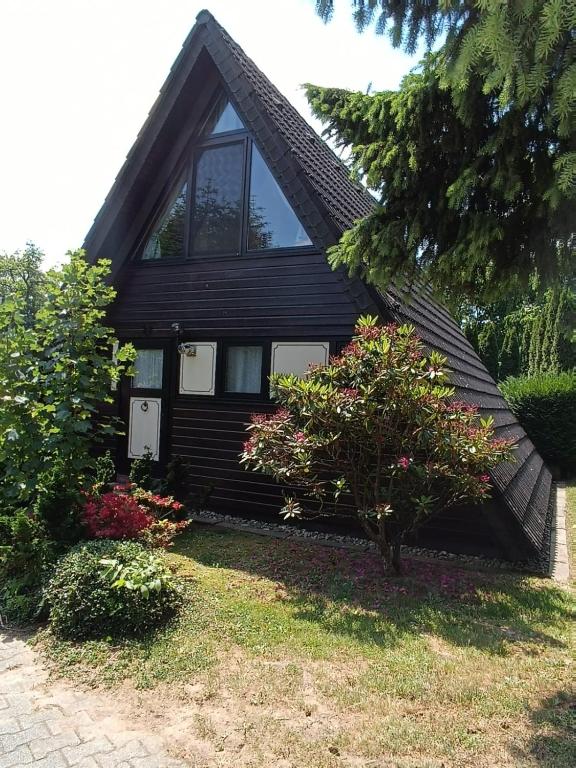 a black house with some flowers in front of it at Ferienhaus Eichhörnchennest in Waldbrunn