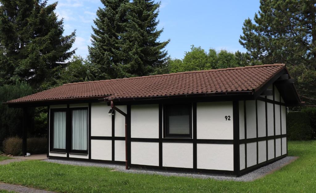 a small white and black building with a brown roof at Ferienhaus Krappennest in Waldbrunn