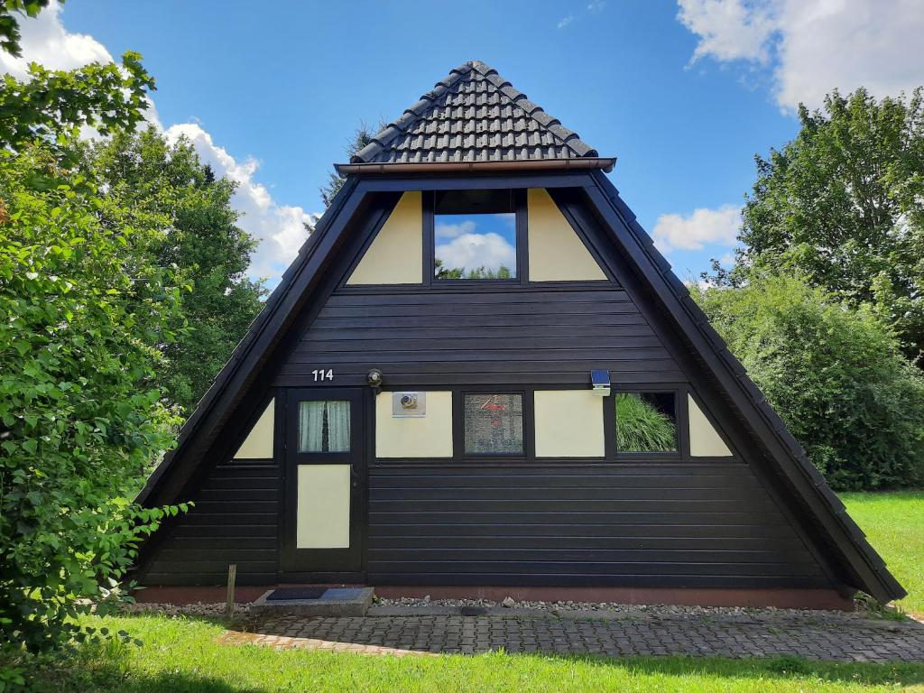 a black house with a gambrel roof at Ferienhaus Winnetou 114 in Waldbrunn