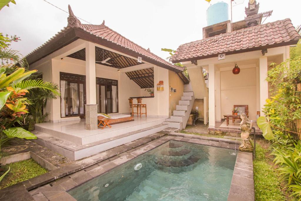a house with a swimming pool in the yard at Jagi Villa in Ubud