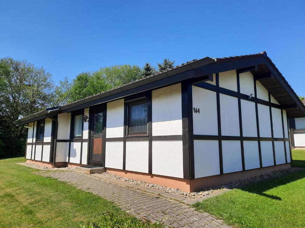 a building with white and black windows on a field at Ferienhaus Romantiklicht in Waldbrunn