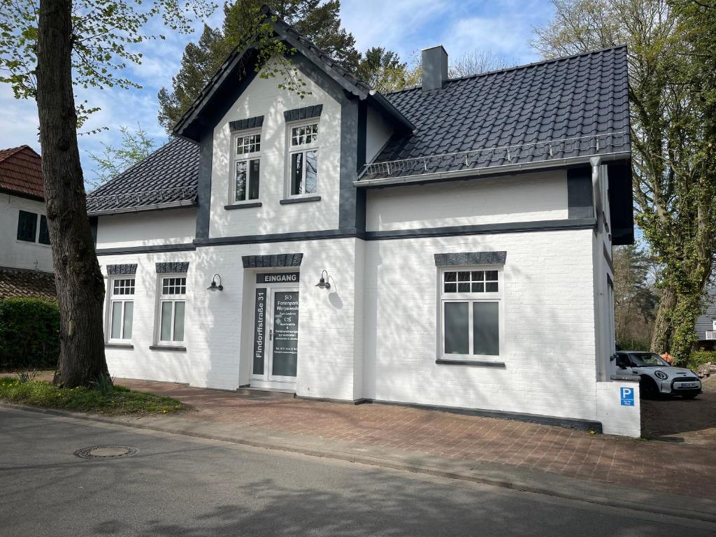 a white house with a black roof at Ferienpark Worpswede in Worpswede