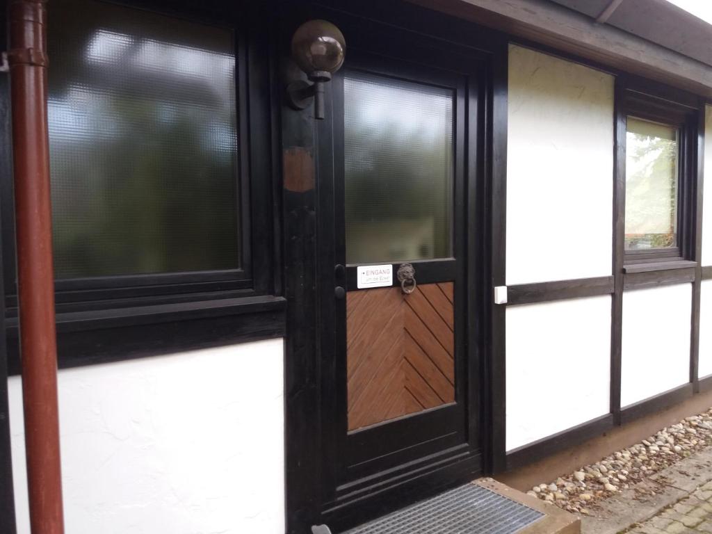 a black door with a sign on it next to windows at Ferienhaus Romantikruhe in Waldbrunn