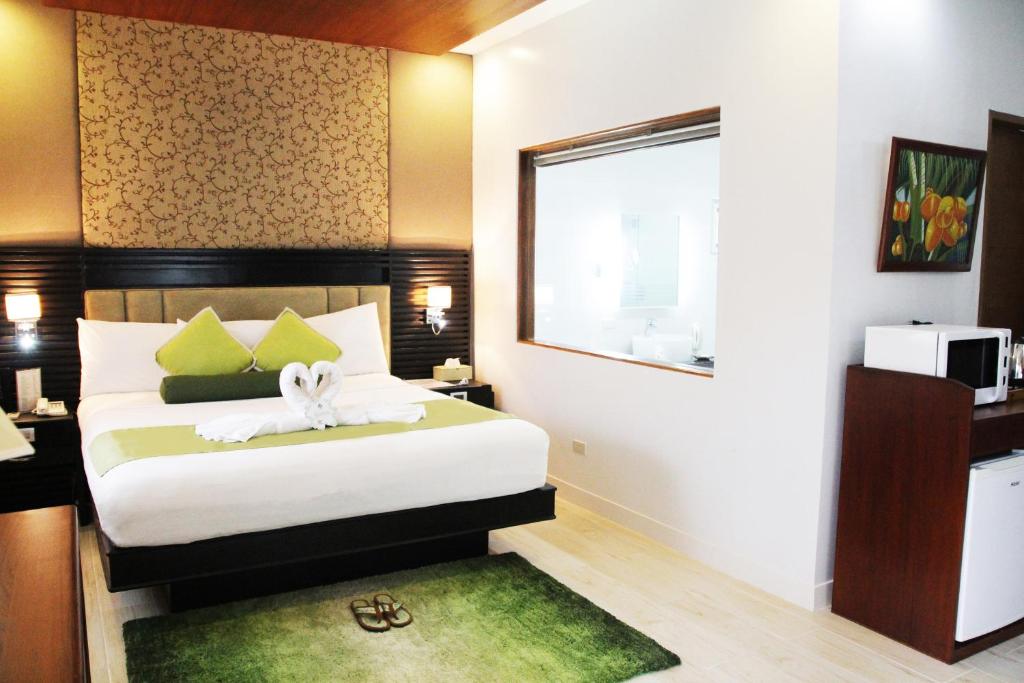 sypialnia z łóżkiem z zielonym dywanem w obiekcie Batangas Country Club w mieście Batangas