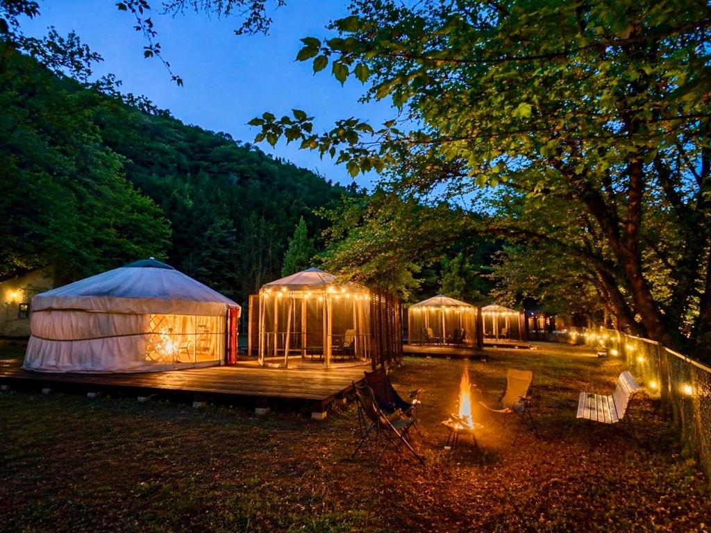 a group of tents with lights in a field at みどりの村 in Ogano