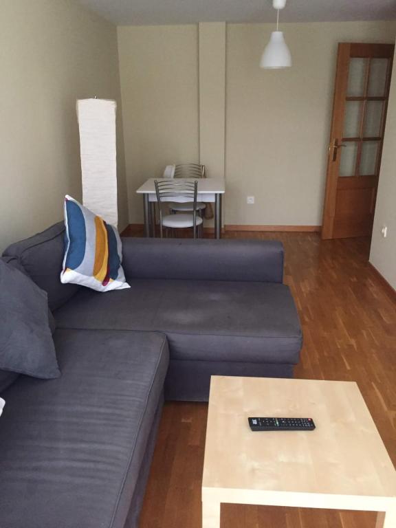 a living room with a blue couch and a table at Apartamentos Ria de Foz in Foz