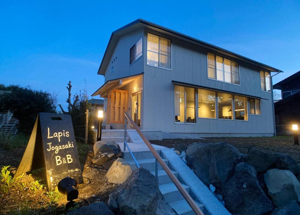 a house with a sign in front of it at Lapis Jogasaki B&B in Ito