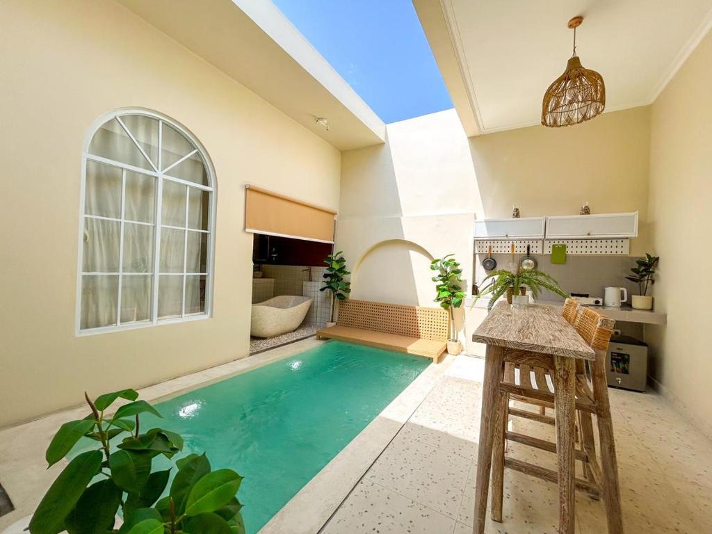 a swimming pool in a living room with a table and chairs at At Paviliun With Private Pool in Timuran