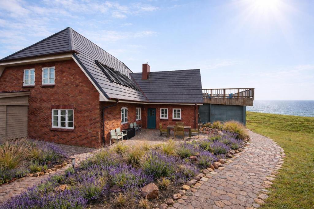 a red brick house with a gravel driveway at Kapitänshaus Meerblick in Langeneß