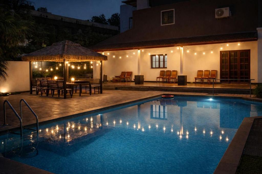 a swimming pool at night with a table and chairs at Sais lotus villa -Home stay and Event venue in Coimbatore