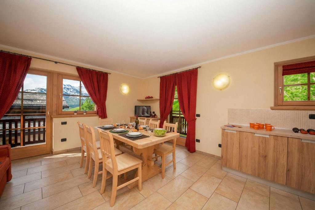 eine Küche und ein Esszimmer mit Tisch und Stühlen in der Unterkunft Sponda Ski in- Ski out 50m - Happy Rentals in Livigno