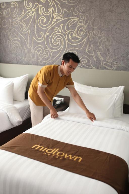 Postel nebo postele na pokoji v ubytování Midtown Hotel Samarinda