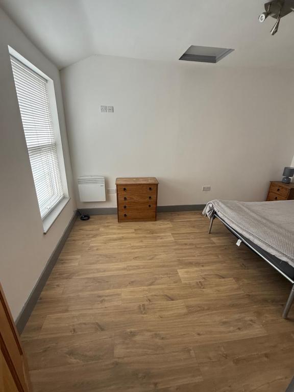 a bedroom with a bed and a wooden floor at Flat 4 Rylands Street in Warrington