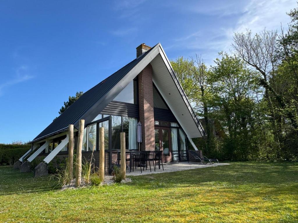 a house with a black roof on top of a field at De Vlier 8* in Nieuwvliet