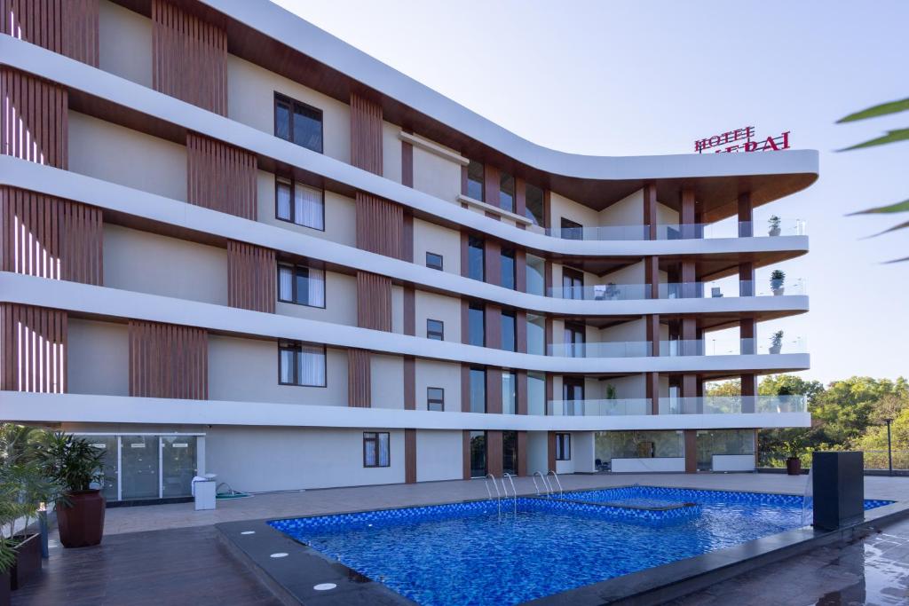 Außenansicht eines Hotels mit Swimmingpool in der Unterkunft Hotel PUMERAI in Honāvar