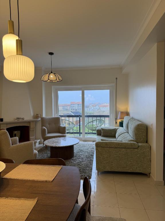 a living room with a couch and chairs and a table at Aqui na Praia do Pedrogão in Leiria