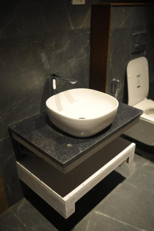 a white sink on a black counter in a bathroom at Mahamaya Hotel in Gohpur