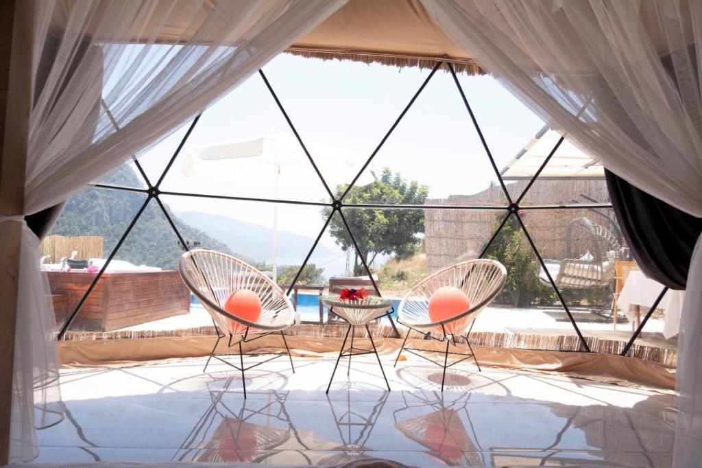 two chairs and a table in front of a window at Kabak Freedom Deluxe Hotel in Faralya