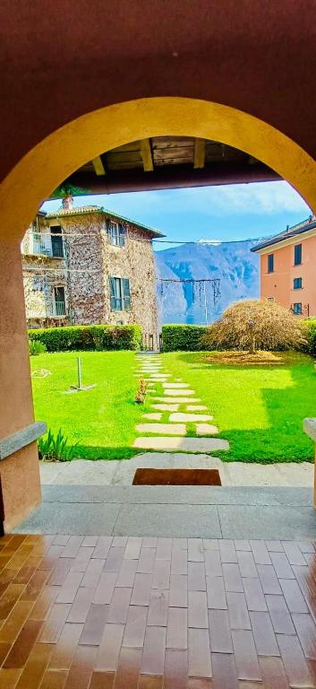 a view from an archway of a building and a green field at Renzo in Bellagio