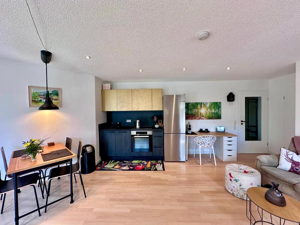 a kitchen and living room with a table and a couch at Appartement Zirbe in Rickenbach