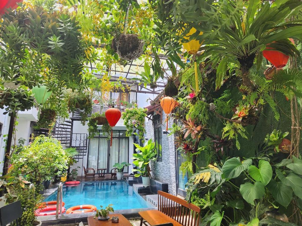 a garden with a swimming pool and plants at Anh Family Homestay in Hoi An