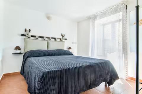 a bedroom with a bed with a blue blanket on it at Casa Normanna in Palermo