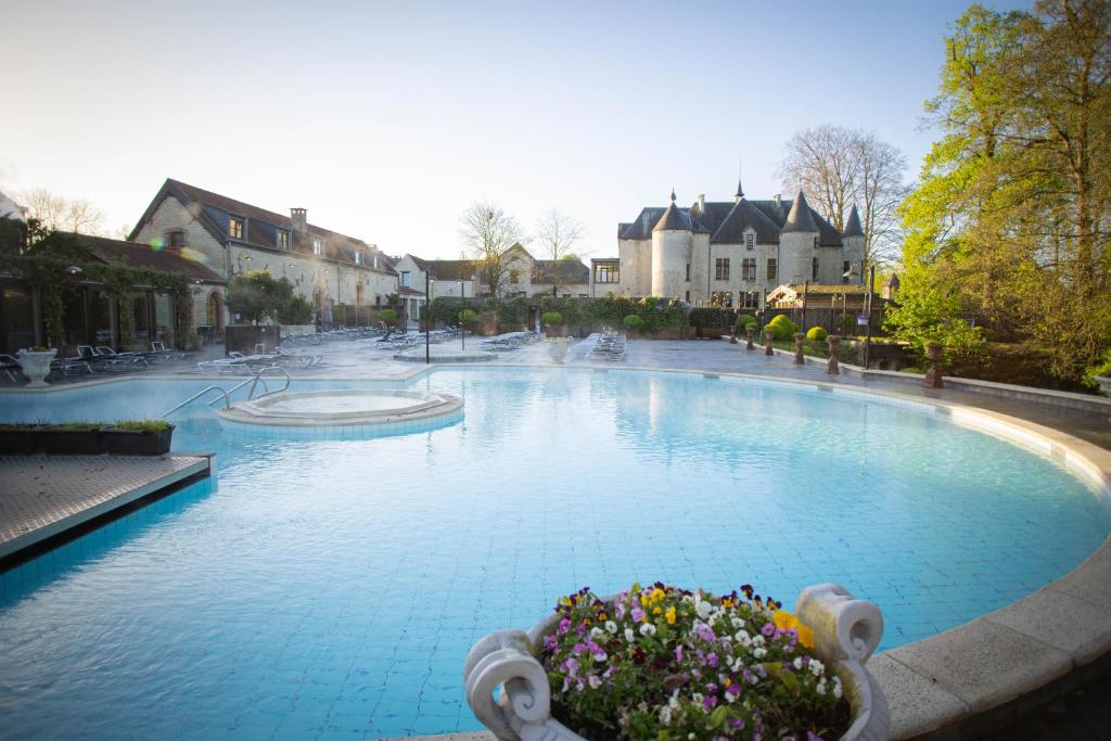 a large swimming pool with flowers in the middle at Thermae Boetfort Hotel in Steenokkerzeel