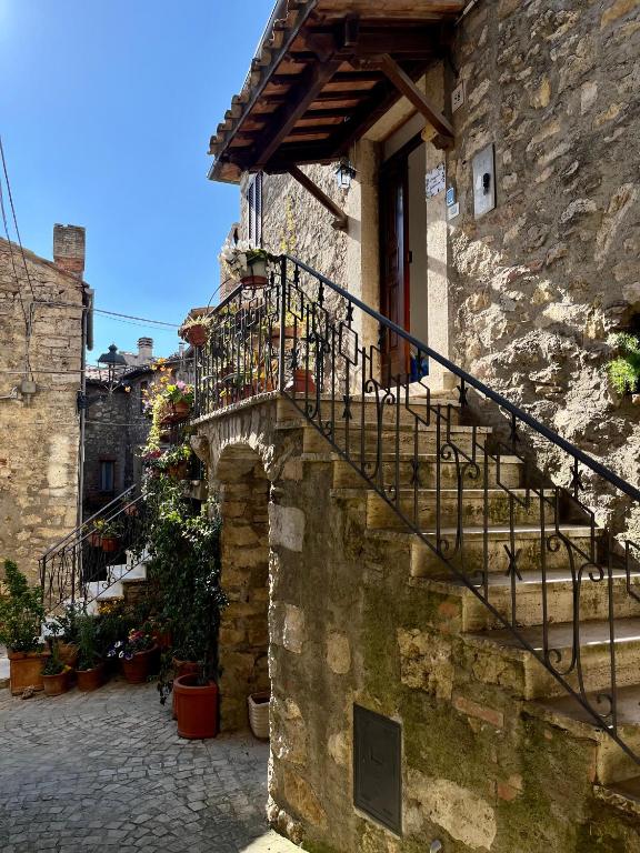 a stone building with stairs and a balcony at Locanda dei Gelsomini in Civitella Del Lago