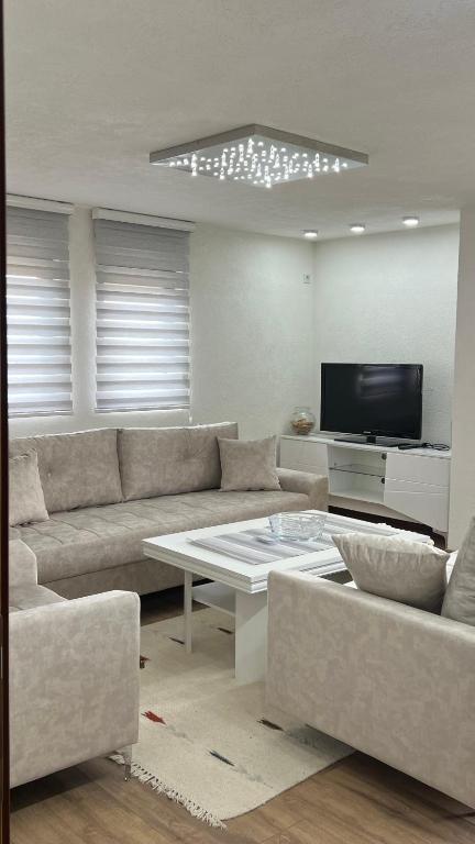 a living room with a couch and a table at Behar Apartment with City View in Sarajevo