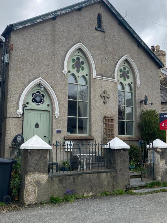 a house with a green door and a fence at The chapel in Machynlleth