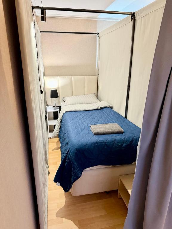 a bedroom with a bed with a blue comforter at Hostel Chisinau Centru in Chişinău